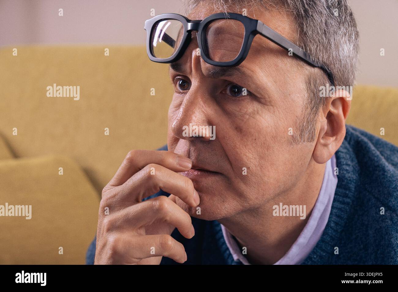 Reifer Mann, der sich ängstlich und überwältigt fühlt, während er zu Hause denkt. Vorstellung von mentalem Stress, Sorge, Überdenken und psychologischem Druck in allen Stockfoto