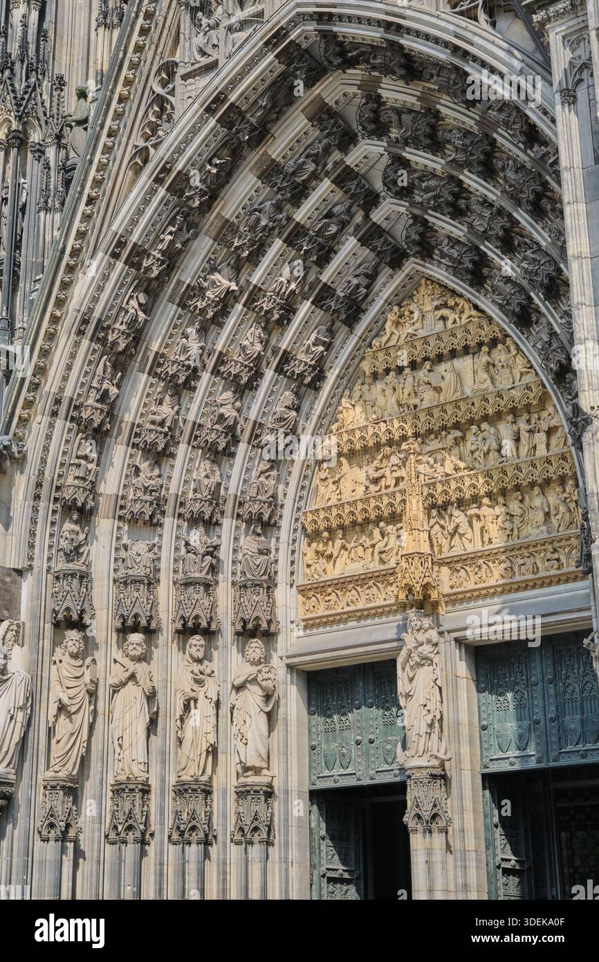 Faszinierende Nahaufnahme des komplizierten gotischen Bogens und der Skulpturen des Kölner Doms. Dieses Bild zeigt die meisterhafte Handwerkskunst Stockfoto
