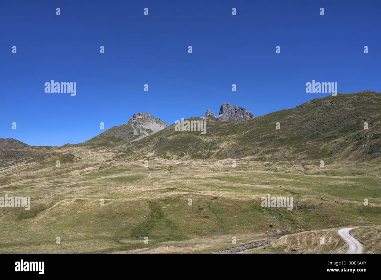 Der Blick auf die weiten, sommerlich braun-grünen Hochwiesen im Cirque d'Aneu zeigt die unverwechselbare Silhouette des PIC du Midi d'Ossau im Hinterland Stockfoto
