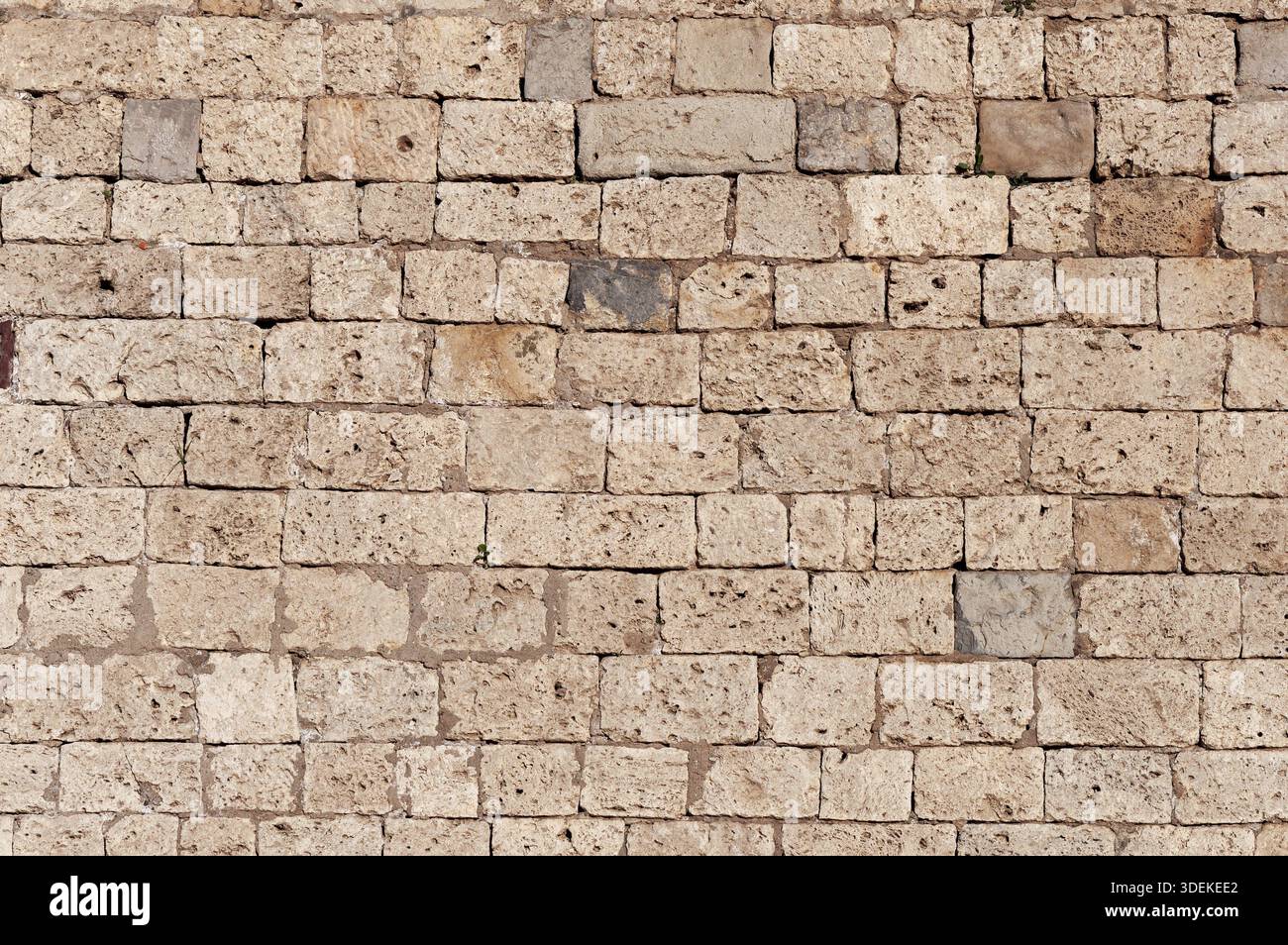 Die Textur der alten braunen Kalksteinwand als Hintergrund Stockfoto