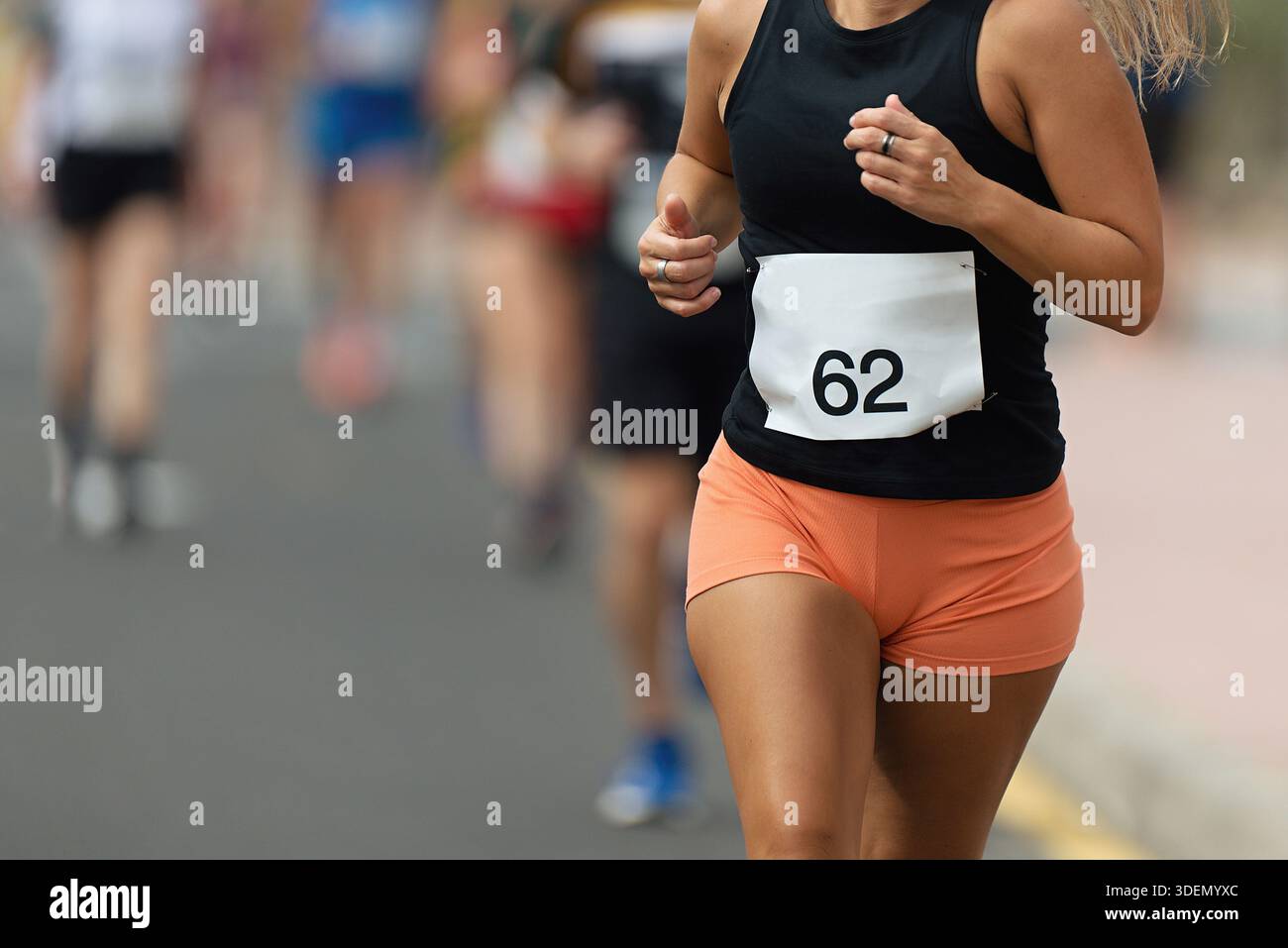 Läuferin, die an sonnigen Tagen im Marathonrennen läuft Stockfoto
