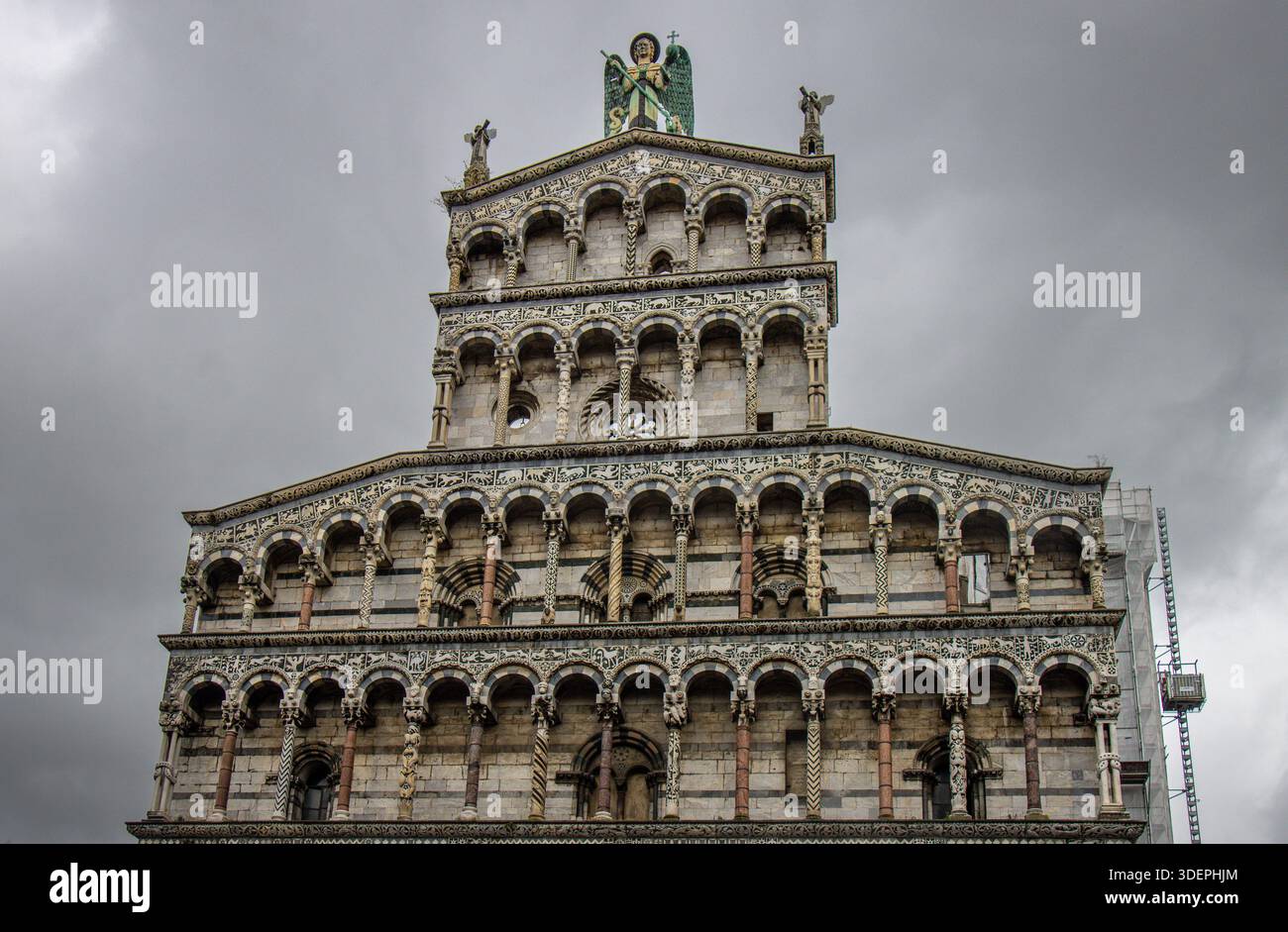 Fachada de la iglesia de San Michele in Foro en Lucca, Italia, ejemplo de arquitectura románica italiana en Mármol blanco bajo un cielo nublado. Stockfoto