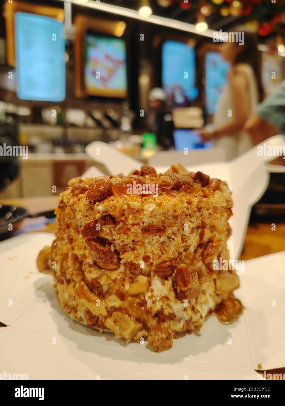 Dekadenter Gourmet-Nuss-Crunch-Kuchen mit karamelisierten Pekannüssen und glasierten Walnüssen Stockfoto