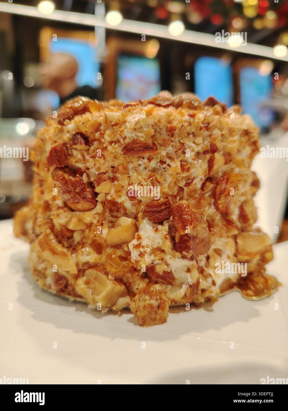 Dekadenter Gourmet-Nuss-Crunch-Kuchen mit karamelisierten Pekannüssen und glasierten Walnüssen Stockfoto