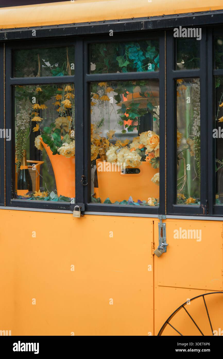 Gelber Bus mit Blumen in einer Vase an der Haustür. Stockfoto
