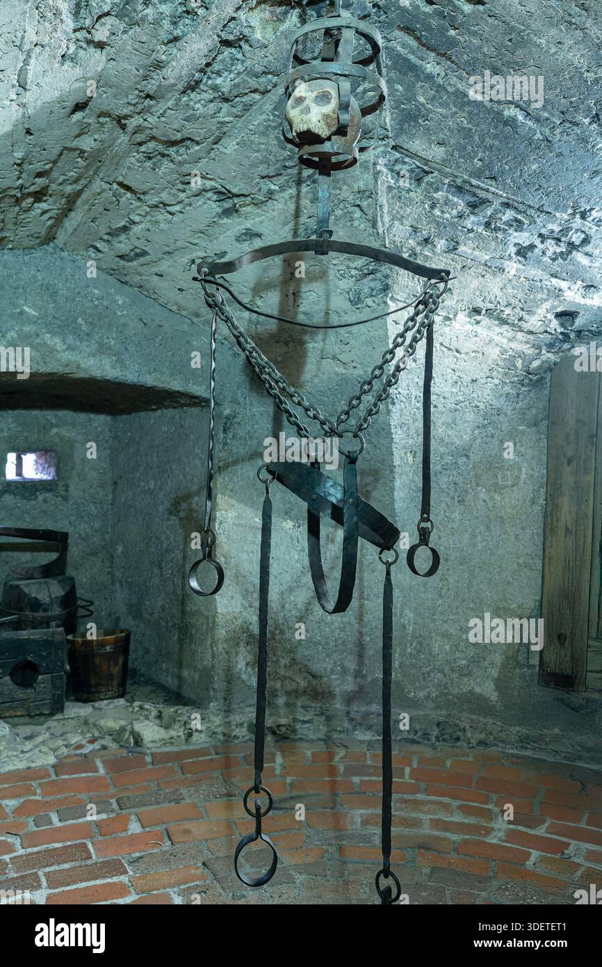 Hängendes Eisenfolterinstrument mit schweren Ketten und Gurten über Einem Ziegelboden in Einem Burgverlies in Prag, Tschechien. Stockfoto
