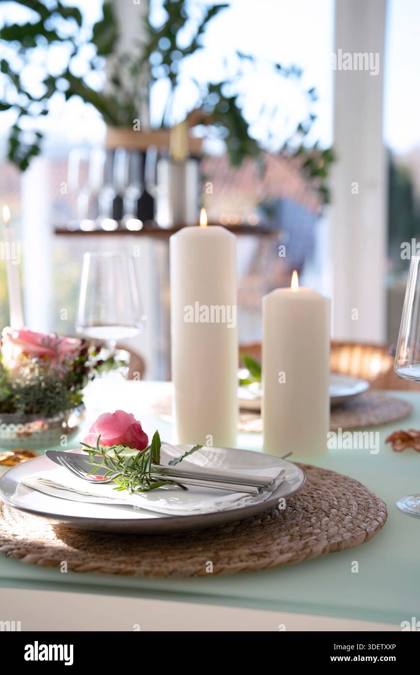 Hochzeitstisch mit rosa Rosen. Festlicher Tisch für ein Hochzeitsessen. Heller, eleganter Restauranthintergrund. Vertikale Nahaufnahme mit kurzer Schärfentiefe. Stockfoto