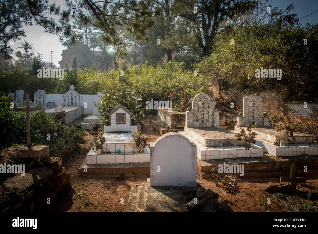 Der Friedhof in Ambositra, Madagaskar. Dieser Abschnitt des Friedhofs hat eine Zahlenschrift mit Beschreibungen in chinesischer Schrift. Diese Gräber spiegeln die Präsenz einer seit langem bestehenden chinesisch-madagassischen Gemeinde im zentralen Hochland Madagaskas wider. Chinesische Migranten kamen Ende des 19. Jahrhunderts in Madagaskar an, viele siedelten sich in zentralen und östlichen Regionen an und gründeten oft Geschäfte und andere Geschäfte in Städten wie Ambositra. Stockfoto