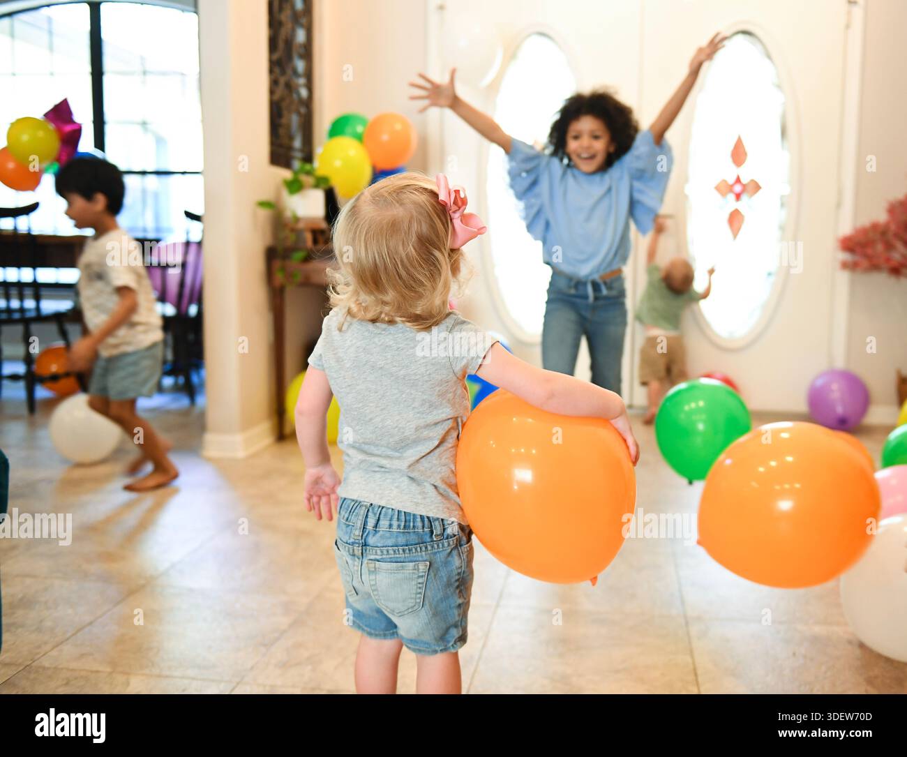 Kinder feiern drinnen mit Ballons und fröhlicher Energie. Stockfoto