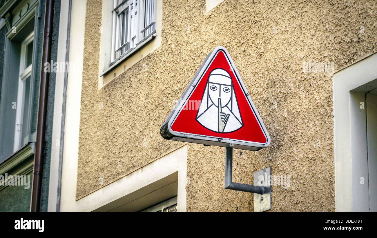 Schild mit einer flüsternden Nonne am Eingang der Privatklinik in Schwabing in München. Stockfoto