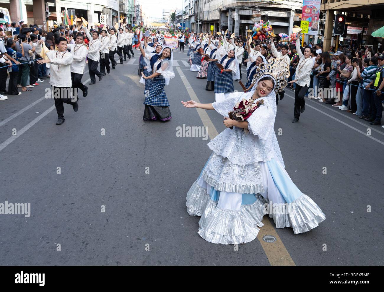 Straßentänzer führen während einer großen öffentlichen Kulturparade eine choreografierte Routine auf, während die Menschenmassen die Route säumen, um sie zu beobachten. Stockfoto