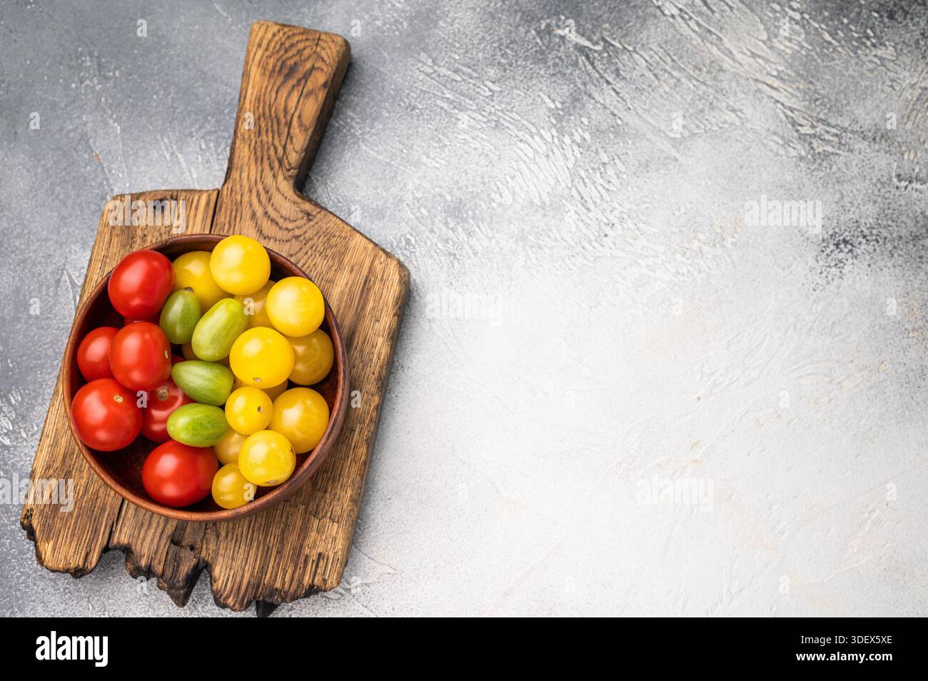 Frische kleine rote, grüne und gelbe Kirschtomaten-Sortiment, Mini-Bio-Cocktail-Tomatenmischung. Weißer Hintergrund. Draufsicht. Stockfoto