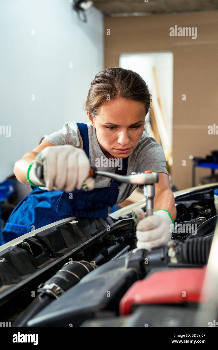 Weibliche Automechanikerin repariert das Auto in der Werkstatt Stockfoto