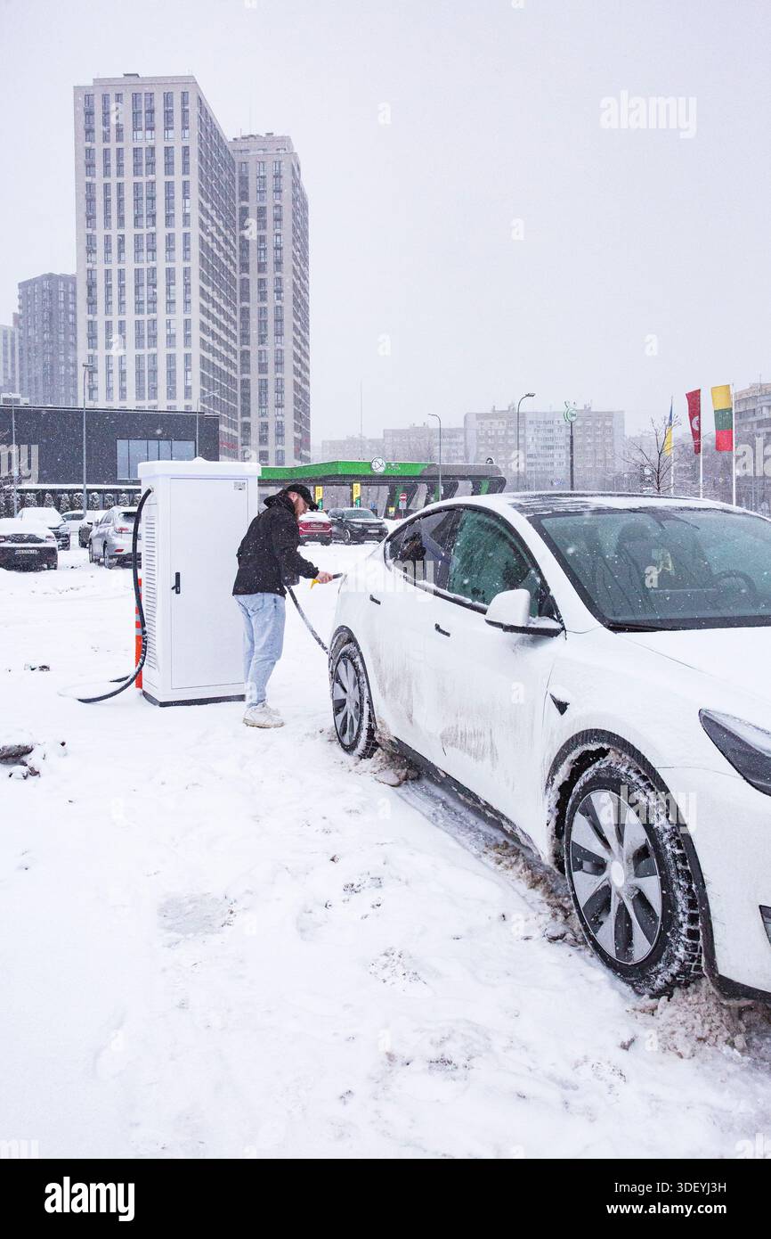 Tesla-Besitzer in der Ukraine lädt sein Elektroauto an einem Wintertag in Kiew während des Krieges auf. Der Dienst bleibt zwischen den Blackouts bestehen Stockfoto
