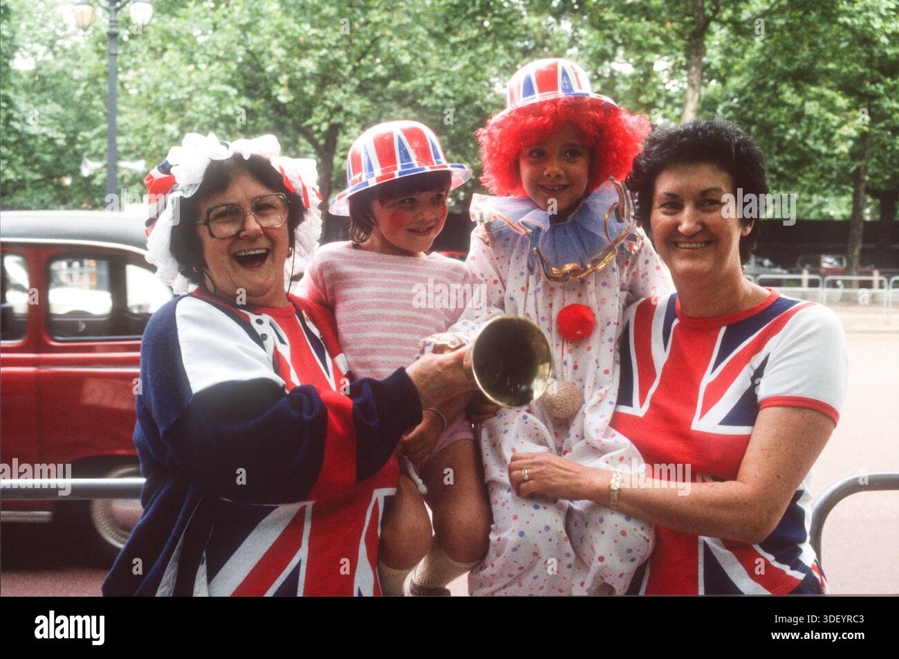 Patriotische Anhänger der königlichen Familie tragen Union Jack-Outfits entlang der Mall zur Hochzeit von Prinz Andrew und Sarah Ferguson am 23. Juli 1986 Stockfoto