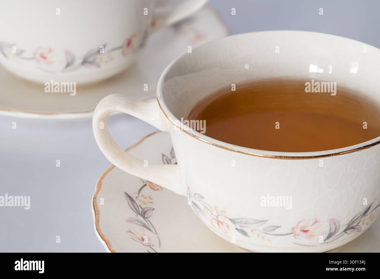 Nahaufnahme von Tee in einer Teetasse auf einer Untertasse mit einer Teetasse im Hintergrund Stockfoto