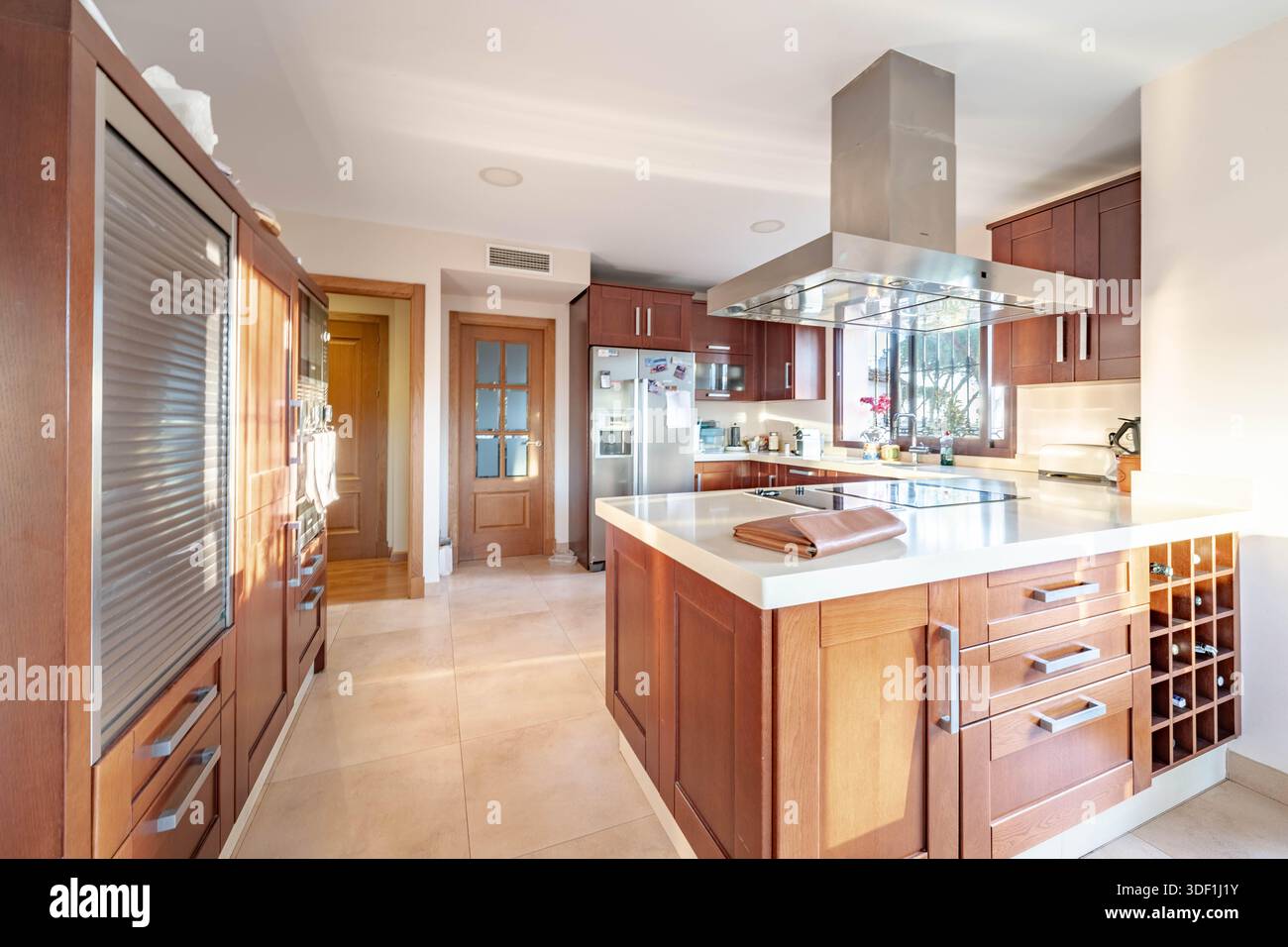 ein Bild einer modernen Küche mit Holzschränken in luxuriöser mediterraner Immobilien Stockfoto