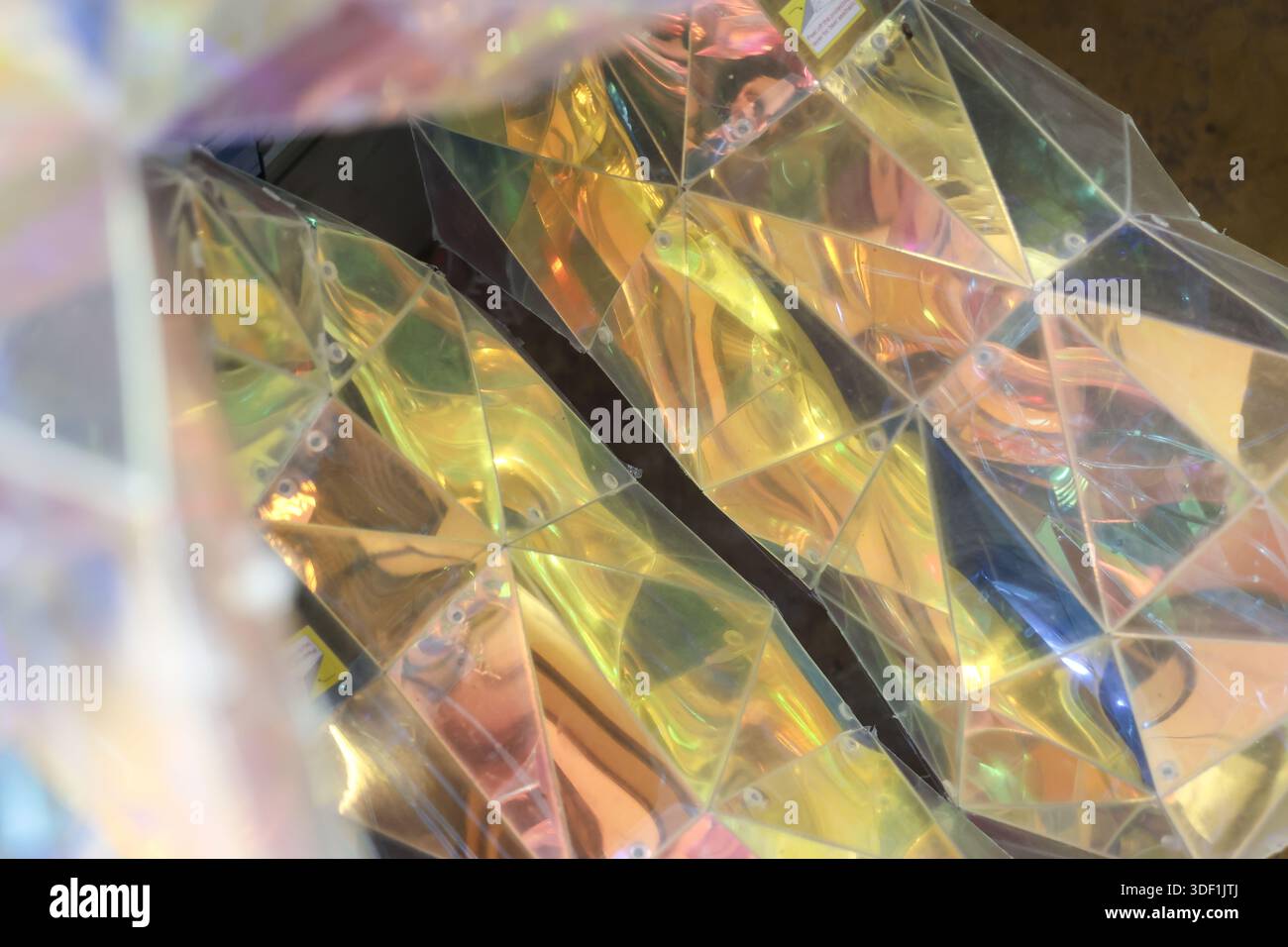 Abstrakter prismatischer Hintergrund mit geometrischen Mustern mit irisierender Reflexion, die lebendige Spektrumfarben zeigen, erzeugt faszinierende, leuchtende Sicht Stockfoto