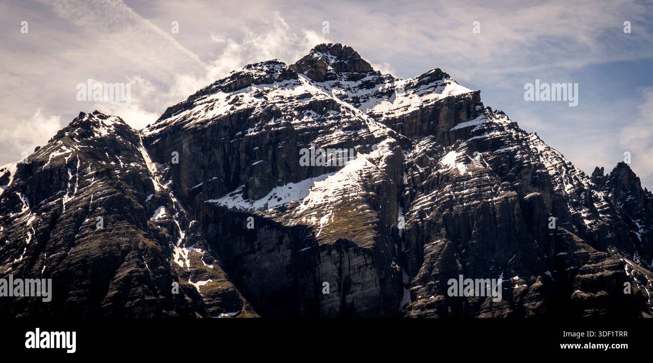 Schneebedeckter Berggipfel unter bewölktem Himmel Stockfoto