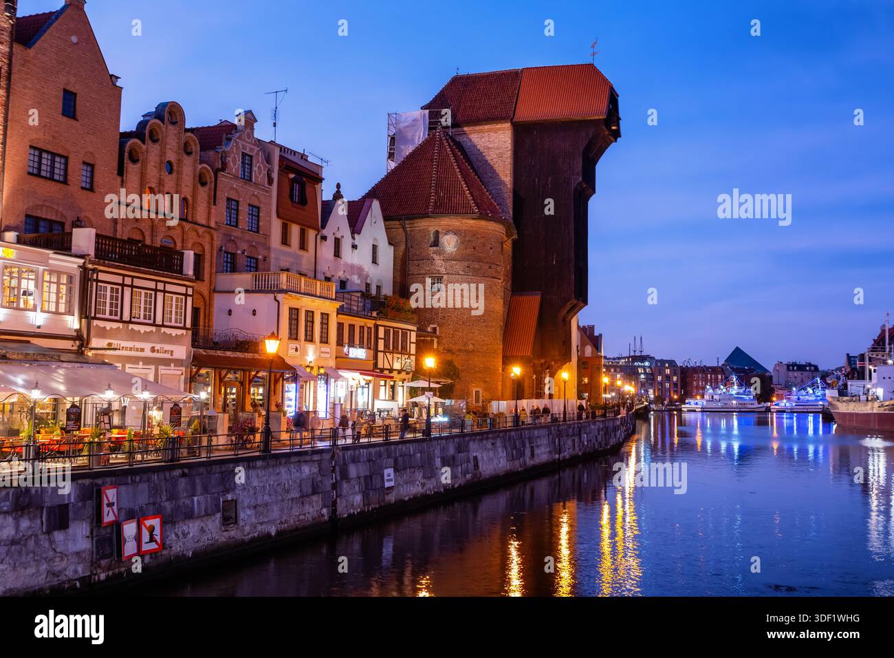 Abend in Danzig in Polen. Altstadt mit mittelalterlichem Kranich, historischen Bürgerhäusern, Cafés und Restaurants am Long Embankment am Motlawa River. Stockfoto