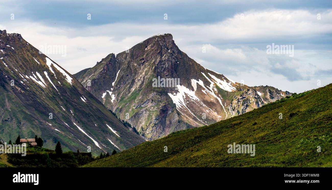 Eine malerische Berglandschaft mit schneebedeckten Gipfeln und einer kleinen Hütte. Stockfoto