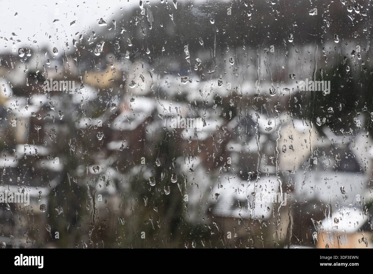 Der Regen flimmert von außen auf die Fensterscheibe Stockfoto
