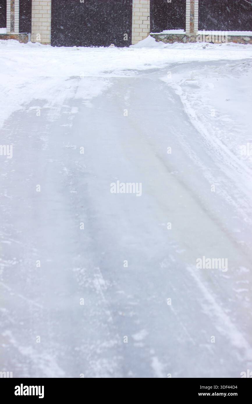 Vereiste Einfahrt in der Nähe des Hauses, gefährliche rutschige Oberfläche im Winter Stockfoto