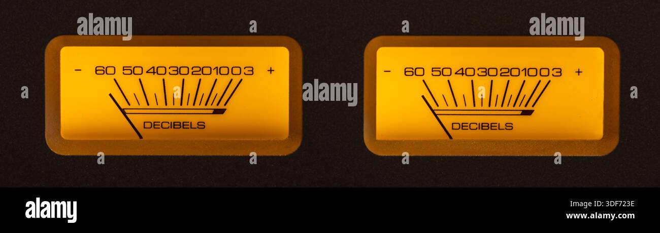 Audio Dual Volume-Geräte leuchten im Dunkeln in Gelb- und Orange-Tönen. Stockfoto