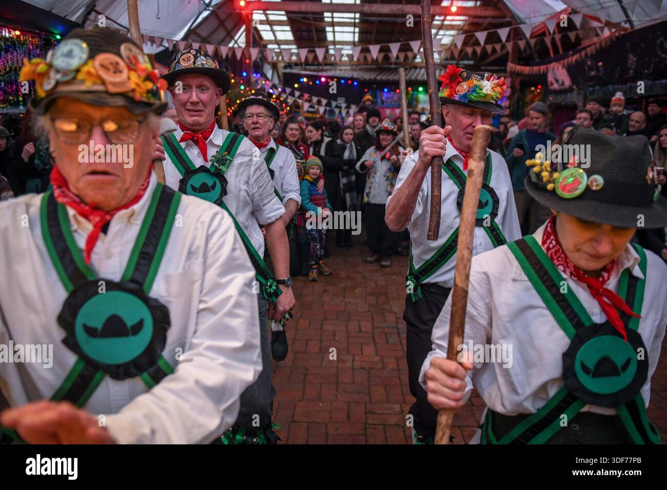 Morris-Tänzer, die während der Mari Lwyd- und Wassailing-Tradition im Gower-Dorf Parkmill in der Nähe von Swansea gezeigt wurden. Der Brauch wurde in den letzten zehn Jahren von den lokalen Gemeinden wiederbelebt und sieht, dass ein Pferdeschädel auf einer Stange montiert wird, bekannt als Mari Lwyd, durch das Dorf geführt wird, um Häuser zu besuchen und symbolisch nahegelegene Apfelbäume zu wecken. Die Veranstaltung zieht mittlerweile Hunderte von Teilnehmern und Besuchern an und trägt dazu bei, diese jahrhundertealte Volkstradition in Südwales zu bewahren. Stockfoto