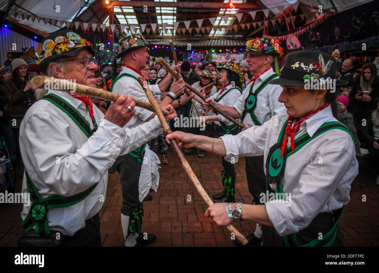 Morris-Tänzer, die während der Mari Lwyd- und Wassailing-Tradition im Gower-Dorf Parkmill in der Nähe von Swansea gezeigt wurden. Der Brauch wurde in den letzten zehn Jahren von den lokalen Gemeinden wiederbelebt und sieht, dass ein Pferdeschädel auf einer Stange montiert wird, bekannt als Mari Lwyd, durch das Dorf geführt wird, um Häuser zu besuchen und symbolisch nahegelegene Apfelbäume zu wecken. Die Veranstaltung zieht mittlerweile Hunderte von Teilnehmern und Besuchern an und trägt dazu bei, diese jahrhundertealte Volkstradition in Südwales zu bewahren. Stockfoto
