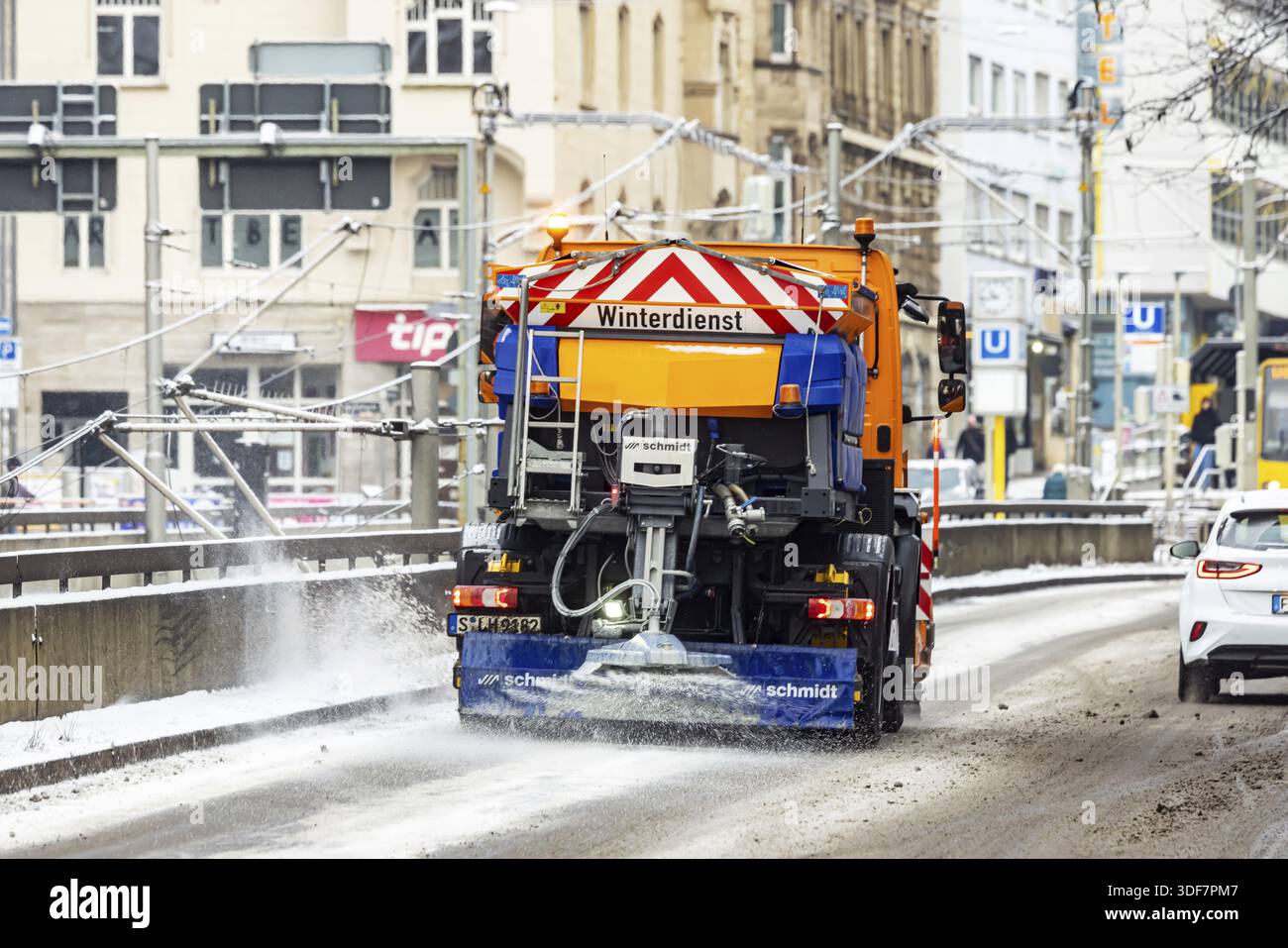 Winter in Stuttgart. Es gibt eine geschlossene Schneedecke im Stadtzentrum. Schneepflug im Winterdienst streut Streusalz. Stuttgart, Baden-Württemberg Stockfoto