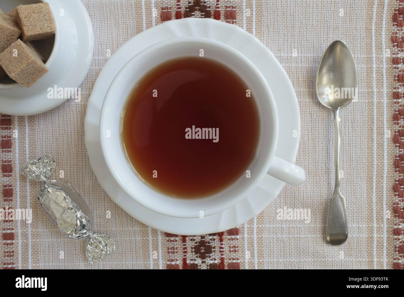 Heißer schwarzer Tee in weißer Tasse auf dem Tisch, Zuckerrohr, Überkopf Stockfoto