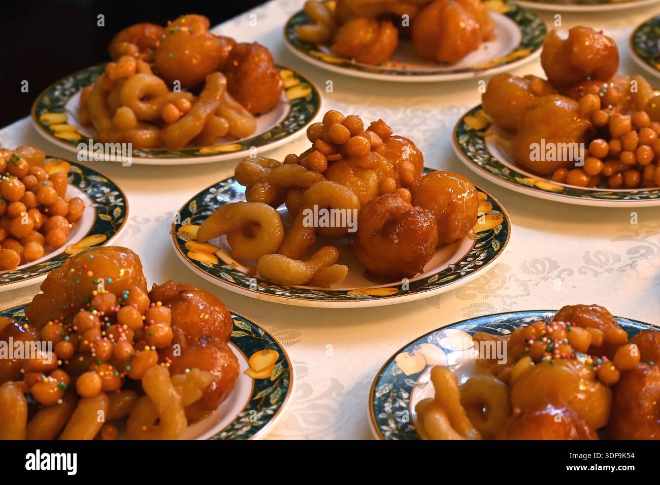 Struffoli neapolitanische gebratene Honigbällchen auf Tellern mit Grüngoldrand für Neujahrsfeiern in Sorrent, Italien Stockfoto