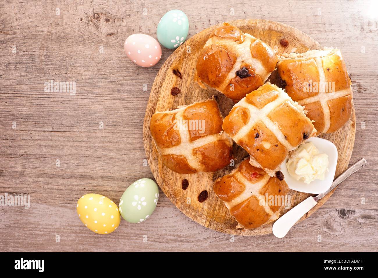 Frische hausgemachte Hot Cross Brötchen auf einem Holzteller. Oben sehen Sie eine Tischszene auf einem Holzhintergrund. Osternahrungskonzept. Stockfoto