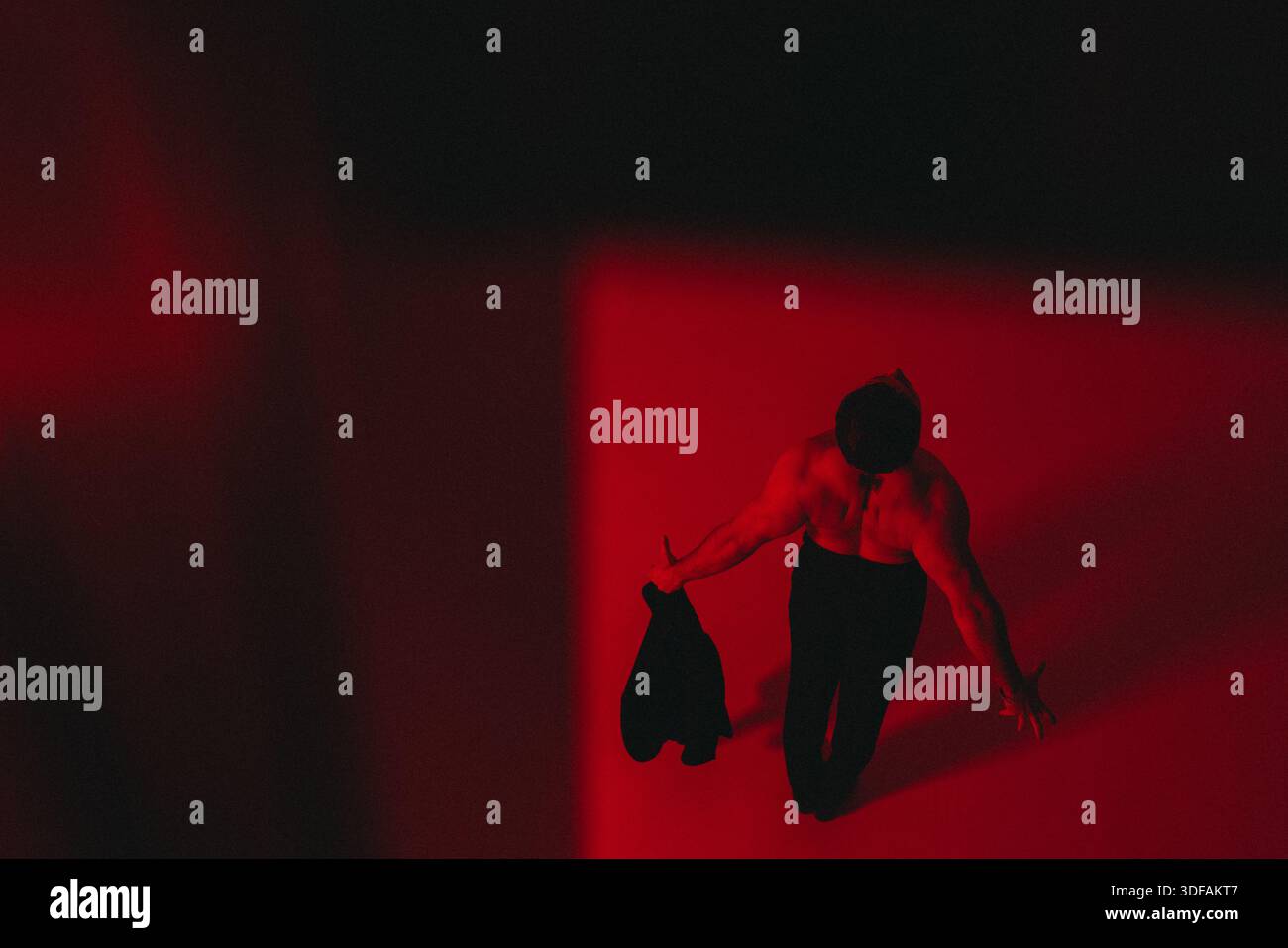 Single man Walking, Individual überquert helle Karmesinstudios Stockfoto