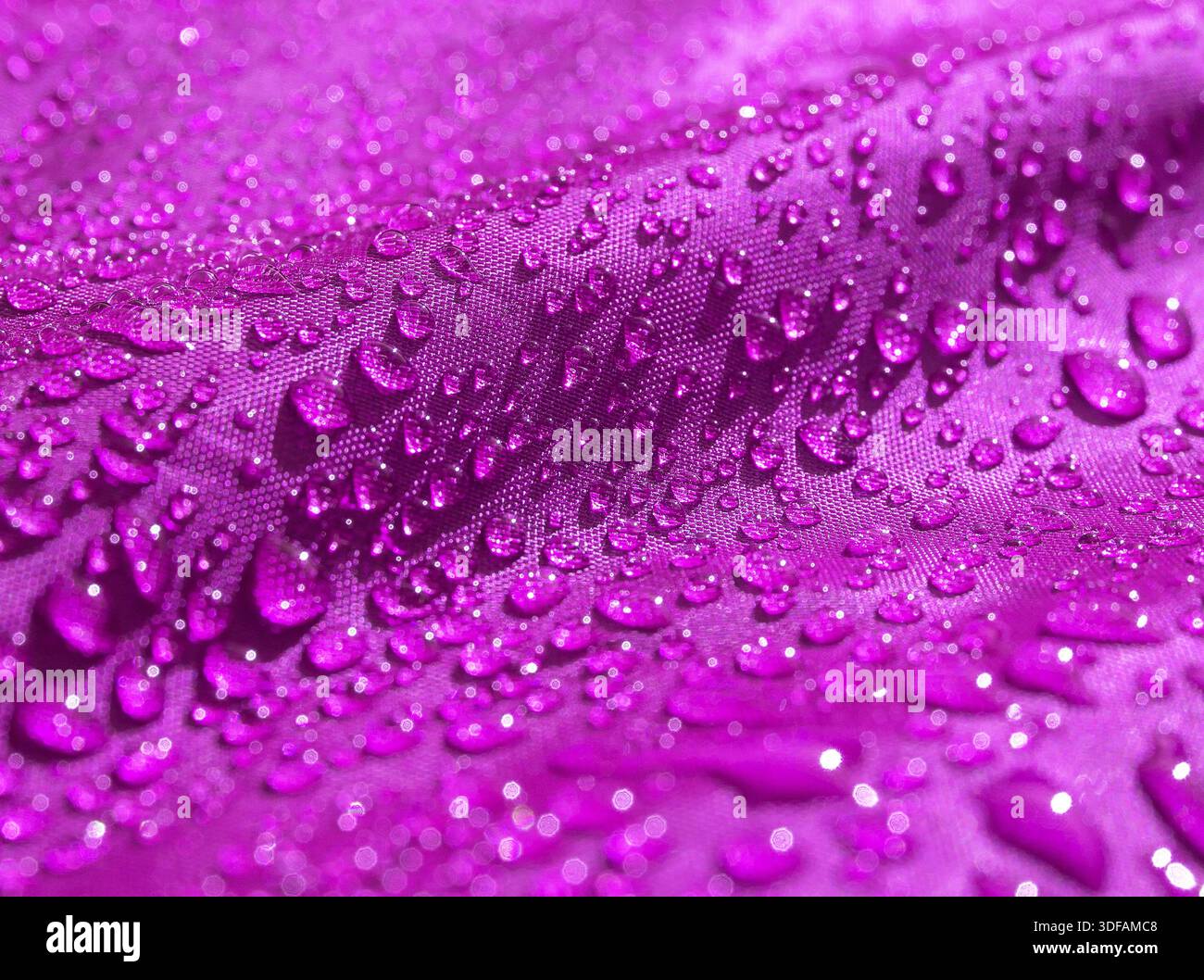 Violettes, wasserdichtes Material mit Wassertropfen aus nächster Nähe Stockfoto