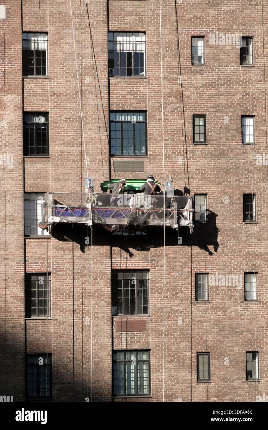 Arbeiter, die Gerüste umbauen, Ziegelfassaden umlegen, defekte Ziegelsteine und Mörtel entfernen, wie es das New York City Local Law 11 vorschreibt, das Reparaturen, regelmäßige Inspektionen und Wartung von Gebäudefassaden vorschreibt, Freitag, den 12. Dezember 2025 in New York City. Foto von Jennifer Graylock-Alamy Stockfoto