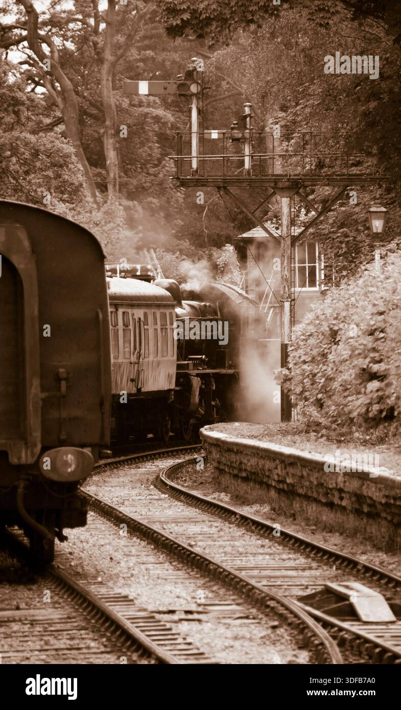 Ein sepiafarbenes Bild einer Dampfeisenbahn, die den Bahnhof verlässt Stockfoto