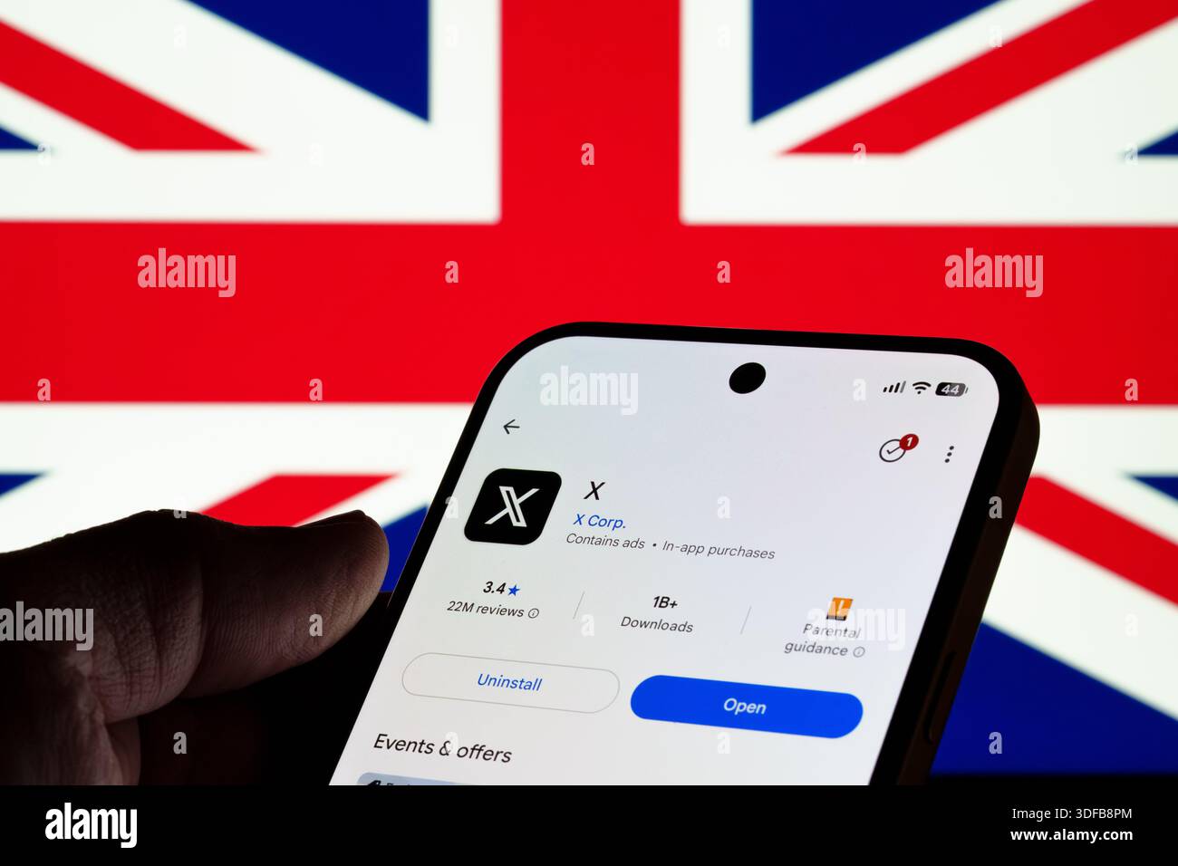 X-App auf dem Bildschirm des Google Play Store in Hand mit Hintergrund der britischen Flagge, Ansicht zur mobilen Installation und Konzept zur Online-Sicherheitsdebatte. Stafford, Uni Stockfoto