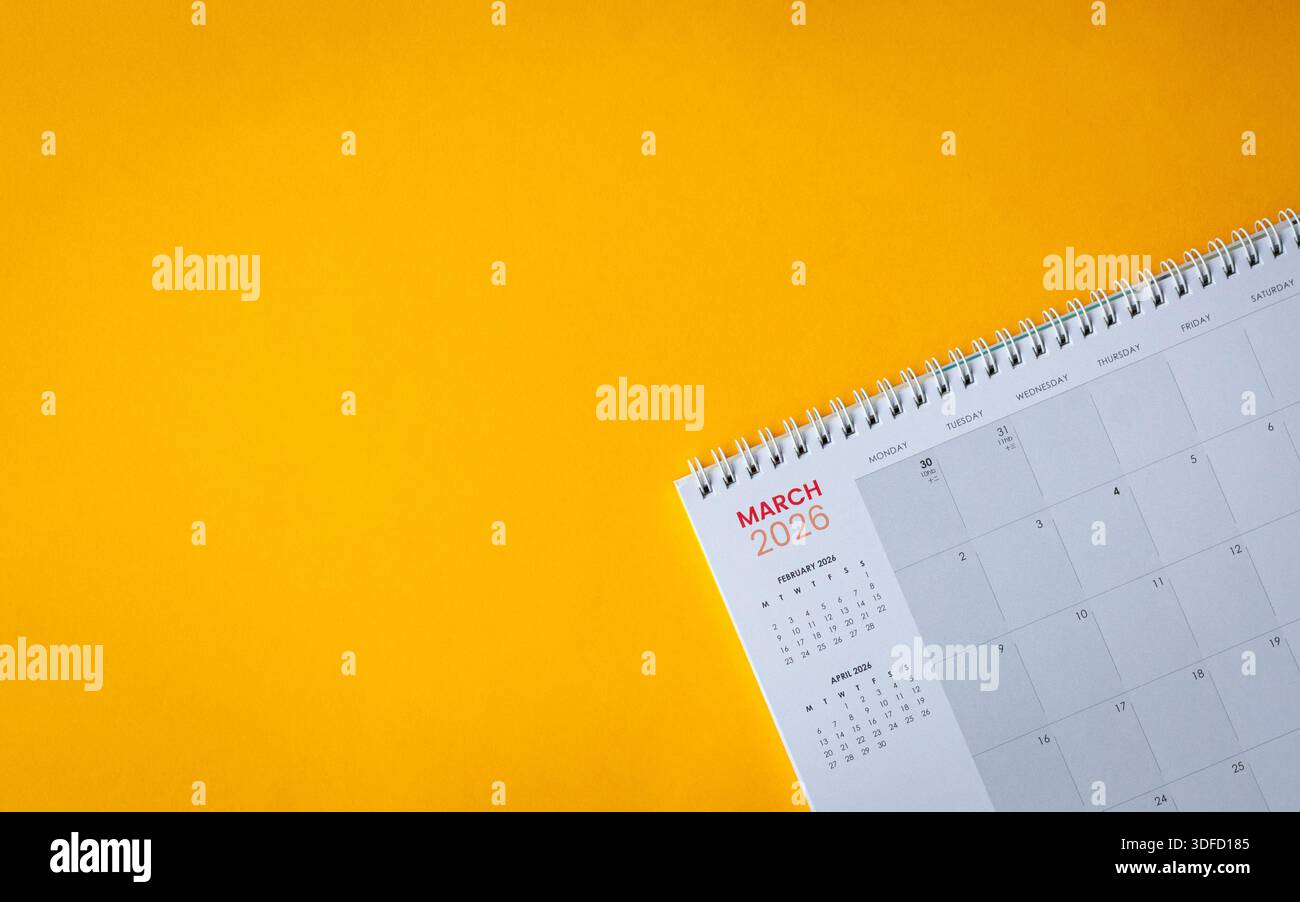 März 2026 Kalender auf gelber Oberfläche. Draufsicht, Kopierraum. Stockfoto