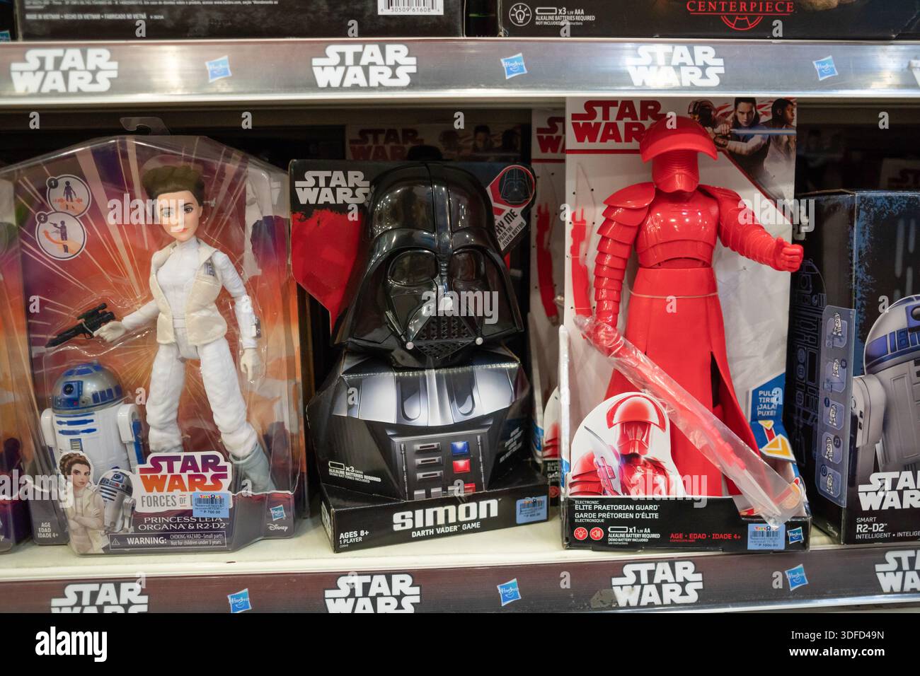 Star Wars-Spielzeug, darunter Prinzessin Leia, Darth Vader und eine Prätorianergarde, die in einem Verkaufsregal in einem Spielwarengeschäft ausgestellt sind, zeigt beliebte Filmartikel. Stockfoto