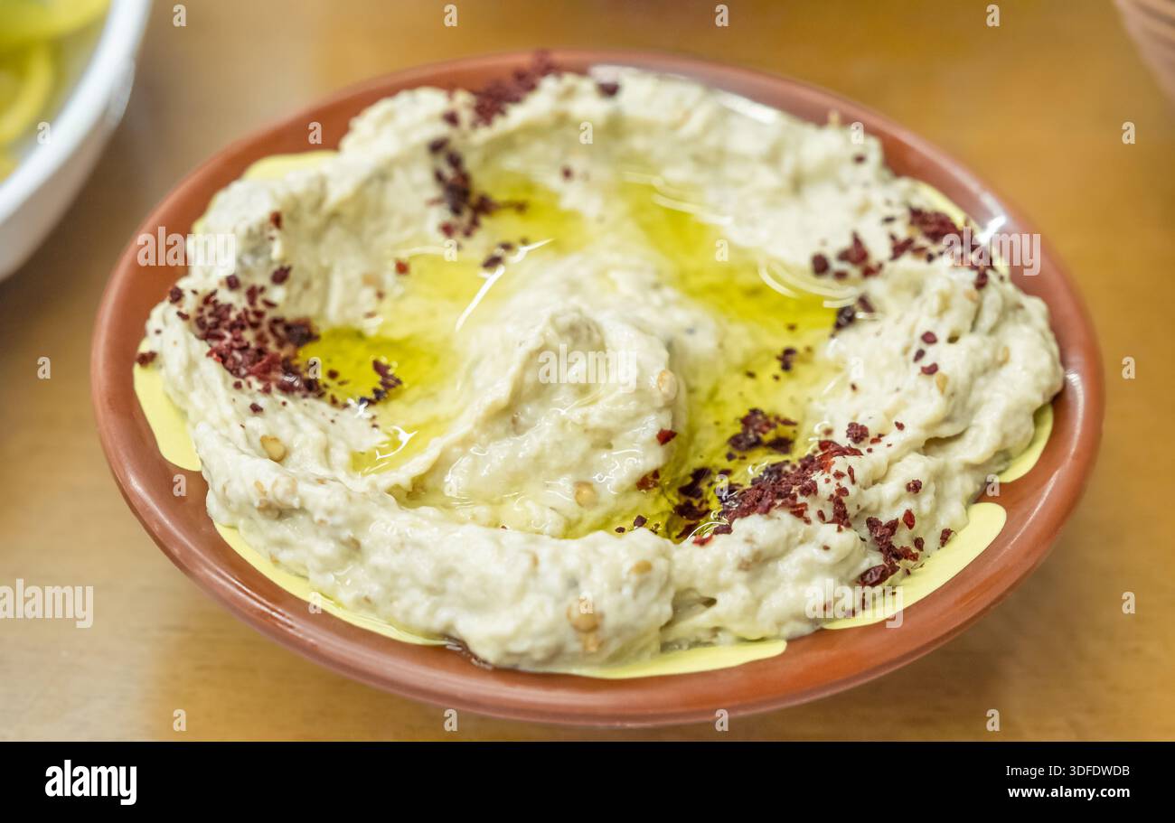 Nahaufnahme Auberginen-Dip Baba Ghanoush mit Kräutern und geräuchertem Paprika. Traditionelle vegane arabische Auberginen-Vorspeise. Auberginen Dip Mutabal mit ta Stockfoto