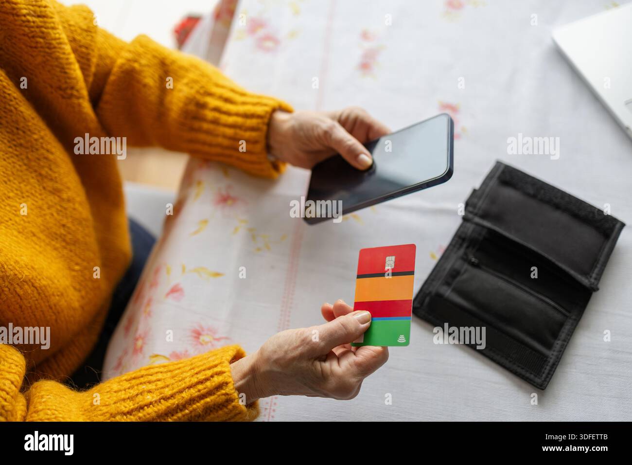 Seniorin beim Online-Shopping mit Smartphone und Kreditkarte Stockfoto