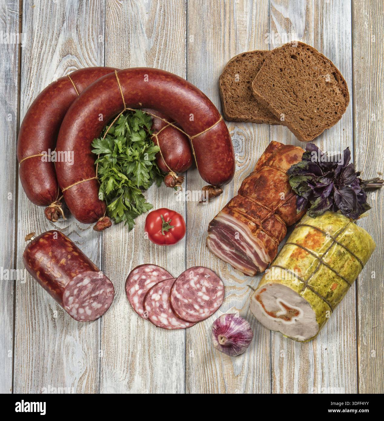 Verschiedene Arten von Würsten mit Gemüse auf einem Holztisch Stockfoto