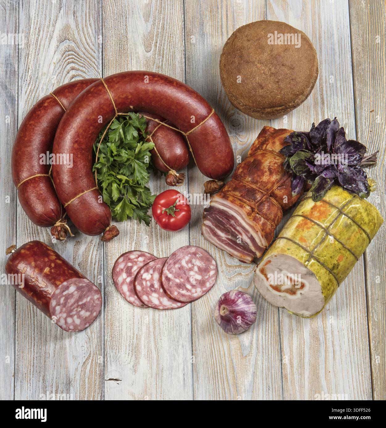 Verschiedene Arten von Würsten mit Gemüse auf einem Holztisch Stockfoto