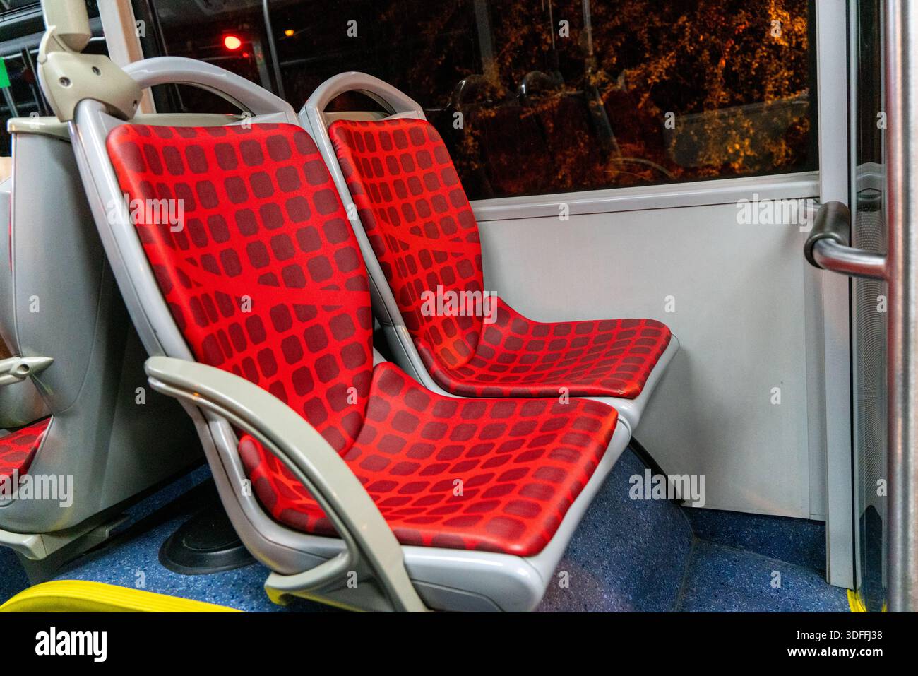 Innenraum eines modernen Busses mit Sitzgelegenheiten in roter Textil Stockfoto