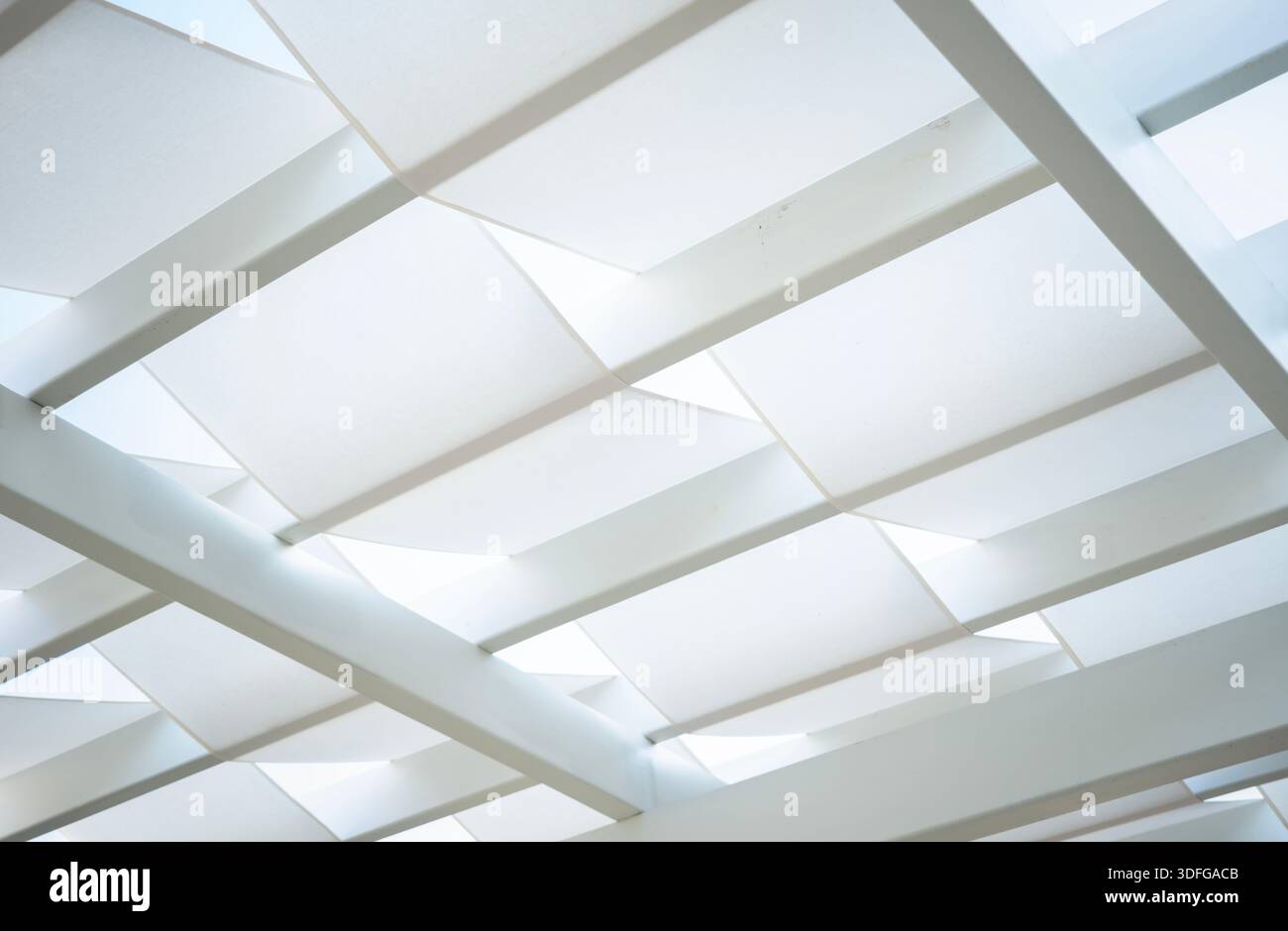 Weiße, moderne, dehnbare Schattenstruktur, die ein geometrisches abstraktes Muster mit klaren Linien und weichem, diffusem Licht bildet Stockfoto