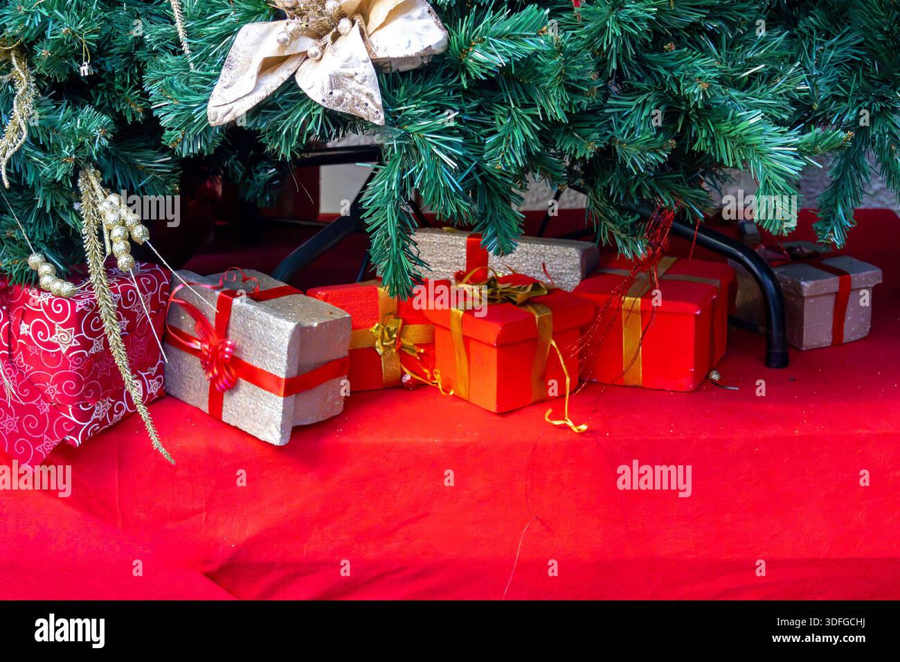 Dekorative, farbenfrohe Verpackungen, die als Weihnachtsgeschenke am Boden eines Baumes serviert werden Stockfoto