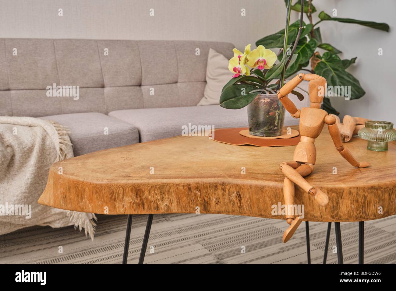 Hölzerne Kunstpuppe auf einem rustikalen Wohnzimmertisch Stockfoto