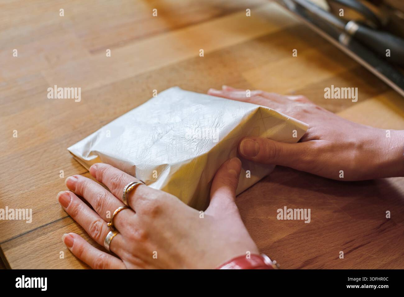 Eine Verkäuferin, die ein Stück Käse einwickelt Stockfoto